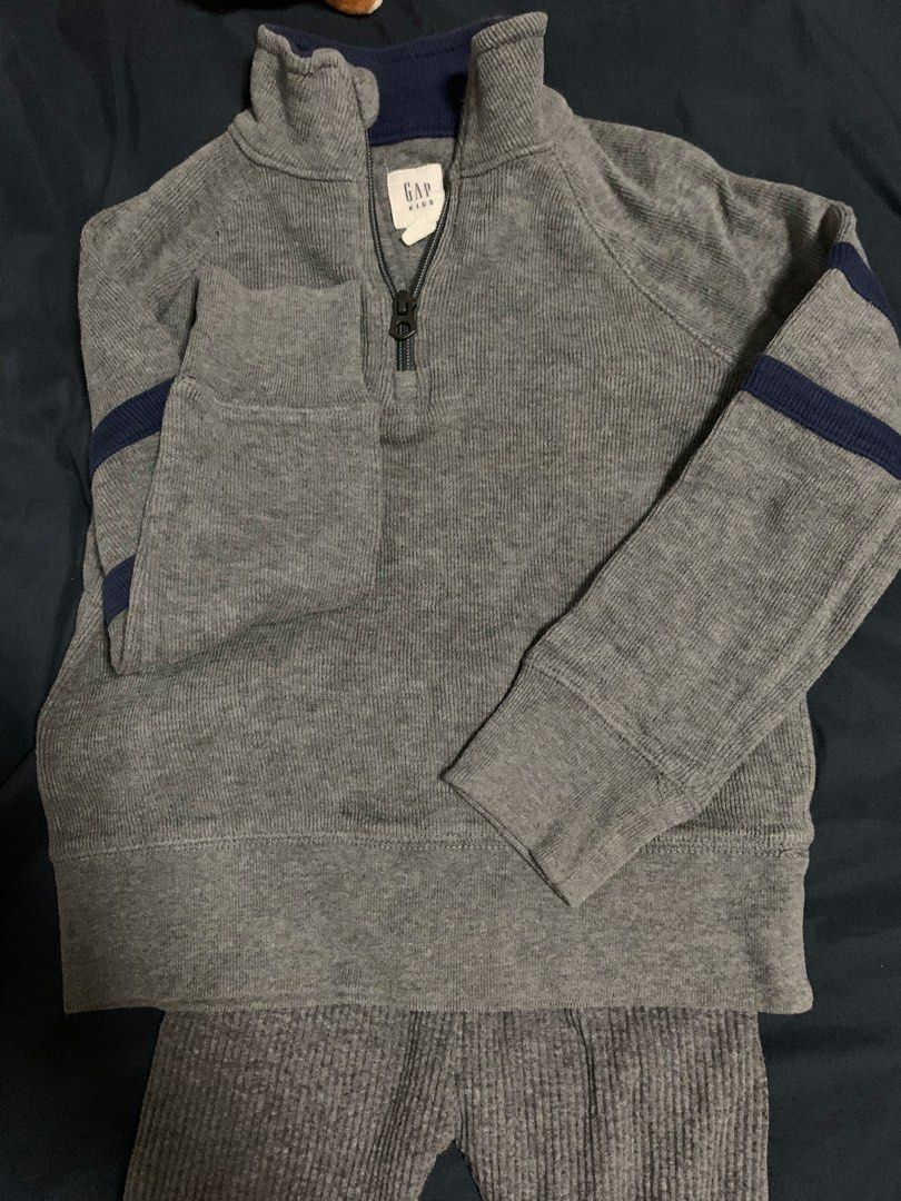 GAP Kids Grey Quarter Zip Sweater (Category: Babies & Kids Fashion) located in Malabon City. Submitted by vewonica (Listing ID 1464137531, Image 1). Description: - GAP Kids quarter zip sweater - Size: XS (fits 4-6 years old) - Color: Grey with navy blue accents on collar and sleeves - Features: Chest pocket with zip closure - Material: Ribbed texture - Origin: Made in Indonesia - Perfect for layering.