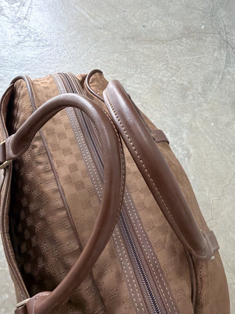 Givenchy Monogram Canvas Leather Trim Duffle Bag (Category: Luxury Bags & Wallets) located in Alfonso. Submitted by jbcamet (Listing ID 1464022294, Image 3). Description: - Authentic Givenchy brown canvas duffle bag - Features signature monogram pattern - Durable leather trim and handles - Secure zipper closure - Interior zippered pocket for essentials - Ideal for weekend trips or as a carry-on - Spacious and fashionable design - Note: Shows some