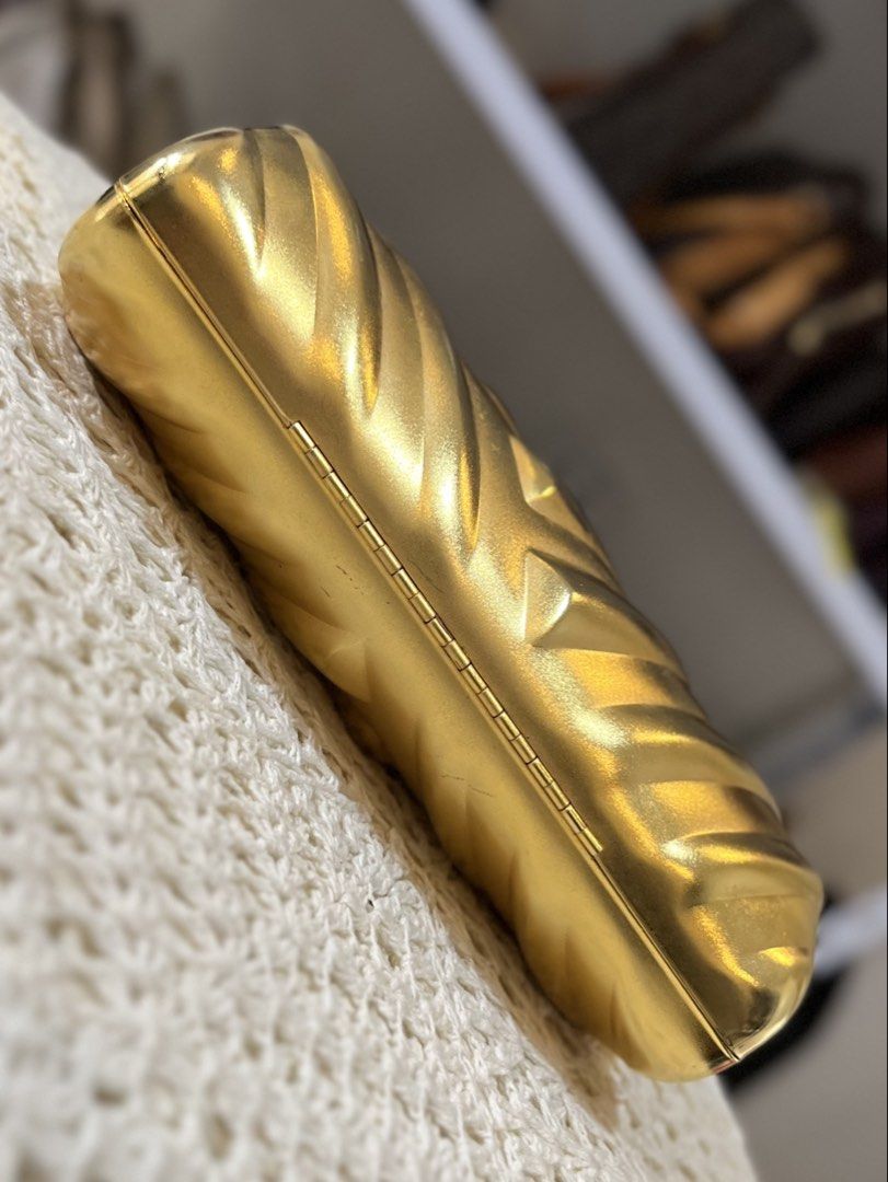 Gold Chevron Clutch Bag with Chain (Category: Luxury Bags & Wallets) located in Bacolod City. Submitted by vintage_vogue6100 (Listing ID 1464017378, Image 2). Description: - Stunning shiny gold clutch bag - Elegant chevron pattern all over - Secure clasp closure - Includes a detachable gold chain strap - Lined with soft black velvet interior - Compact size: 19cm (L) x 9cm (H) x 6cm (W).