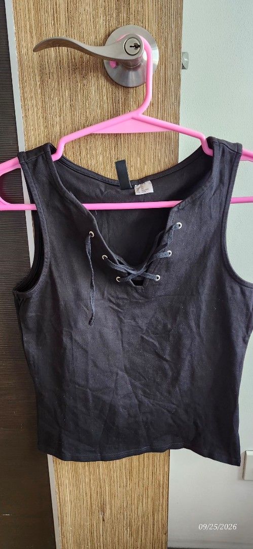 H&M Divided Black Lace-Up Tank Top (Category: Sleeveless) located in Manila. Submitted by atan2025 (Listing ID 1463999908, Image 1). Description: - Brand: H&M Divided - Color: Black - Style: Sleeveless tank top - Feature: Lace-up detail at the front neckline - Versatility: Perfect for layering or wearing on its own - Design: Simple and easy to style.