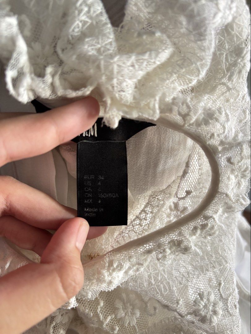 H&M White Lace Trim Sleeveless Top (Category: Sleeveless) located in Paranaque City. Submitted by ggg.bin (Listing ID 1464044939, Image 3). Description: - White sleeveless top from H&M - Features delicate lace trim on neckline and shoulders - Button-up front with gathered bodice detail - Lightweight fabric, ideal for hot weather - Versatile for casual or dressy occasions.