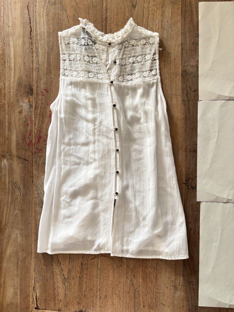 H&M White Lace Trim Sleeveless Top (Category: Sleeveless) located in Paranaque City. Submitted by ggg.bin (Listing ID 1464044939, Image 1). Description: - White sleeveless top from H&M - Features delicate lace trim on neckline and shoulders - Button-up front with gathered bodice detail - Lightweight fabric, ideal for hot weather - Versatile for casual or dressy occasions.