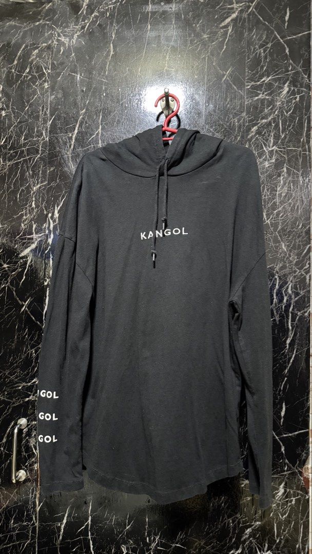 Kangol Black Hoodie Size M (Category: Coats, Jackets and Outerwear) located in Bacoor. Submitted by jiricu1 (Listing ID 1464079969, Image 1). Description: - Black Kangol hoodie - Size: Medium (M) - Features iconic Kangol logo on the front - 'GOL' repeated on the left sleeve - 'Kangol Born British Established in 1938' printed on the right sleeve - Material: 100% Cotton.