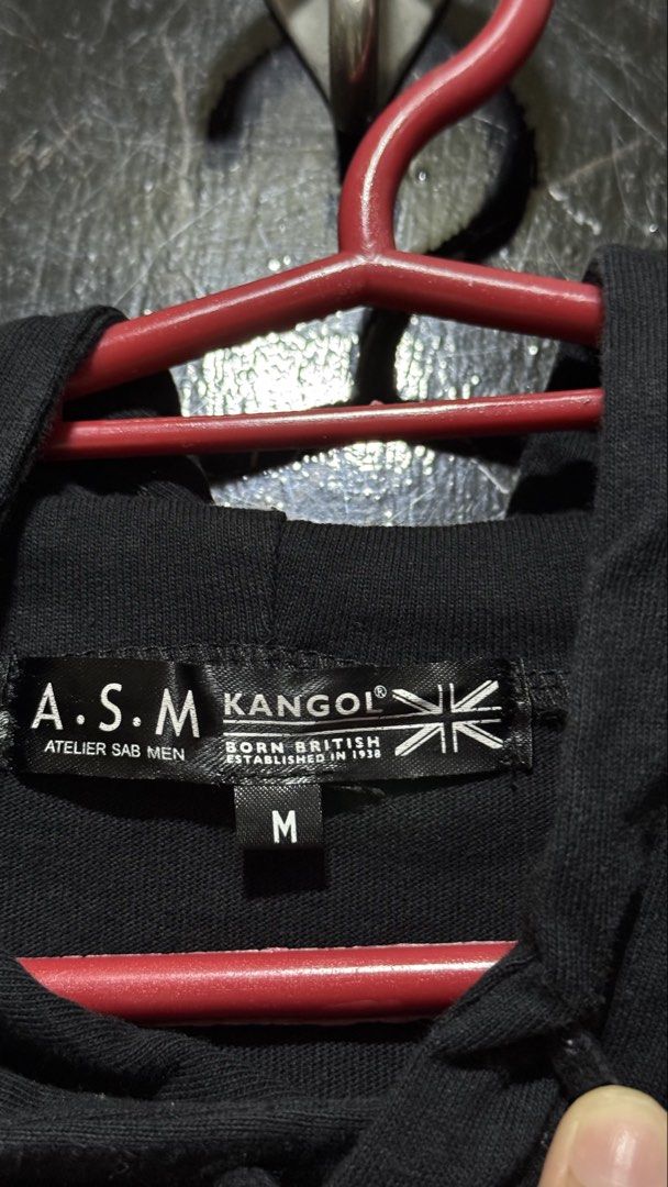 Kangol Black Hoodie Size M (Category: Coats, Jackets and Outerwear) located in Bacoor. Submitted by jiricu1 (Listing ID 1464079969, Image 3). Description: - Black Kangol hoodie - Size: Medium (M) - Features iconic Kangol logo on the front - 'GOL' repeated on the left sleeve - 'Kangol Born British Established in 1938' printed on the right sleeve - Material: 100% Cotton.