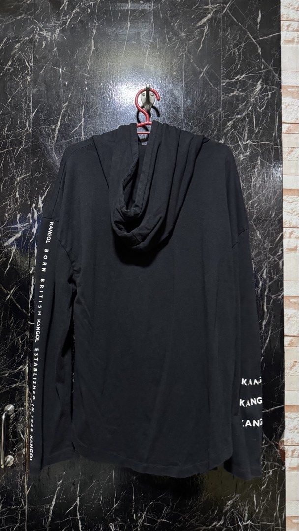 Kangol Black Hoodie Size M (Category: Coats, Jackets and Outerwear) located in Bacoor. Submitted by jiricu1 (Listing ID 1464079969, Image 2). Description: - Black Kangol hoodie - Size: Medium (M) - Features iconic Kangol logo on the front - 'GOL' repeated on the left sleeve - 'Kangol Born British Established in 1938' printed on the right sleeve - Material: 100% Cotton.