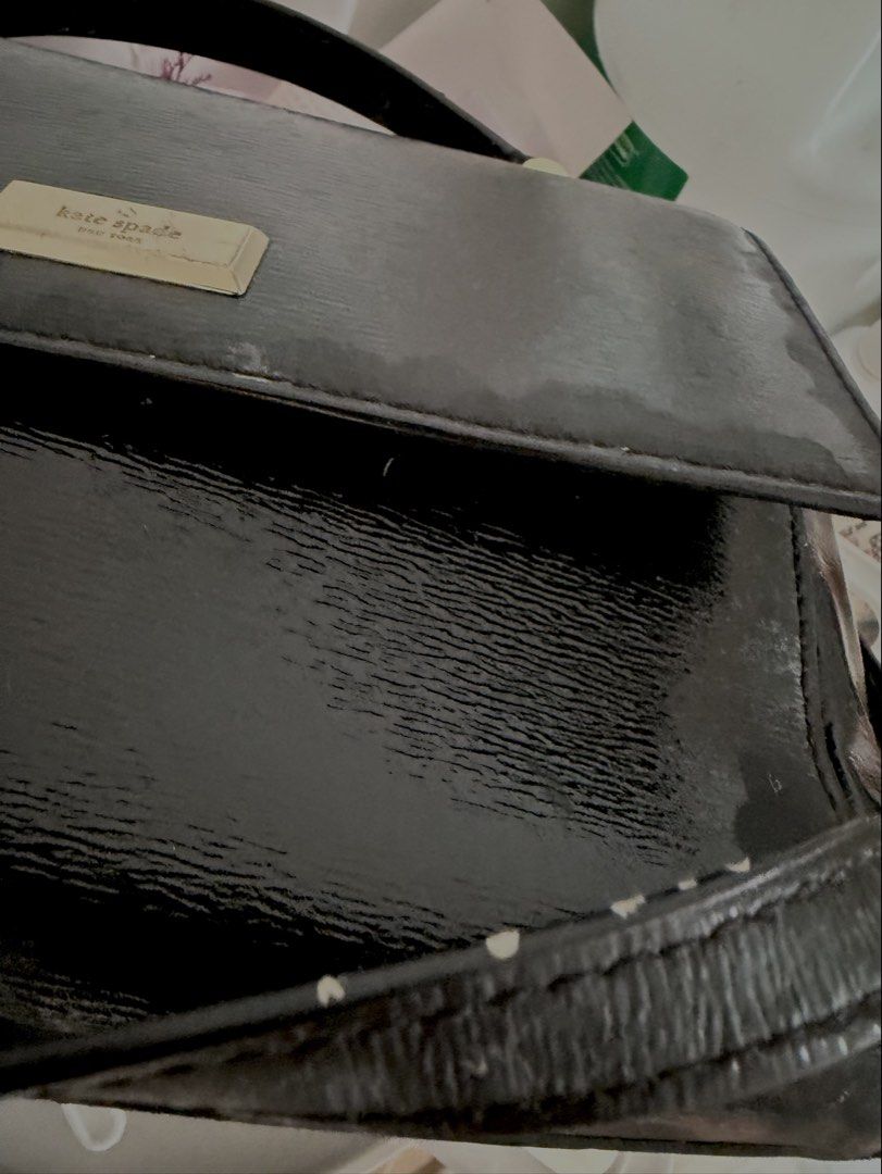 Kate spade bag (Category: Luxury Bags & Wallets) located in Cabanatuan. Submitted by scrlttt (Listing ID 1463947602, Image 3). Description: - Brand: Kate Spade - Material: Black patent leather - Features: Top handle, front flap closure with metal logo plate - Interior: Clean - Occasion: Great for everyday or special events - Condition: Shows some signs of wear on the exterior, consistent with normal use - has a flaw see pictures - can restore or 