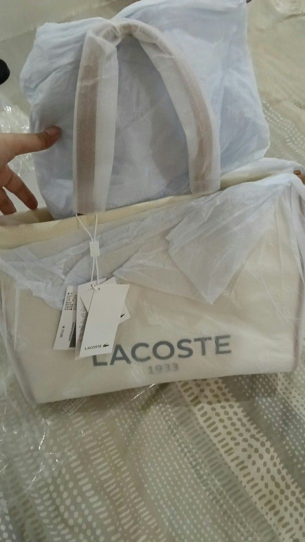 Lacoste 1933 Canvas Tote Bag (Category: Tote Bags) located in Quezon City. Submitted by elihur.tuazon (Listing ID 1464070032, Image 1). Description: - White canvas tote bag - Brown trim and handles - Large Lacoste 1933 logo on front - Brand new with original tags and packaging - Ideal for everyday use or travel.