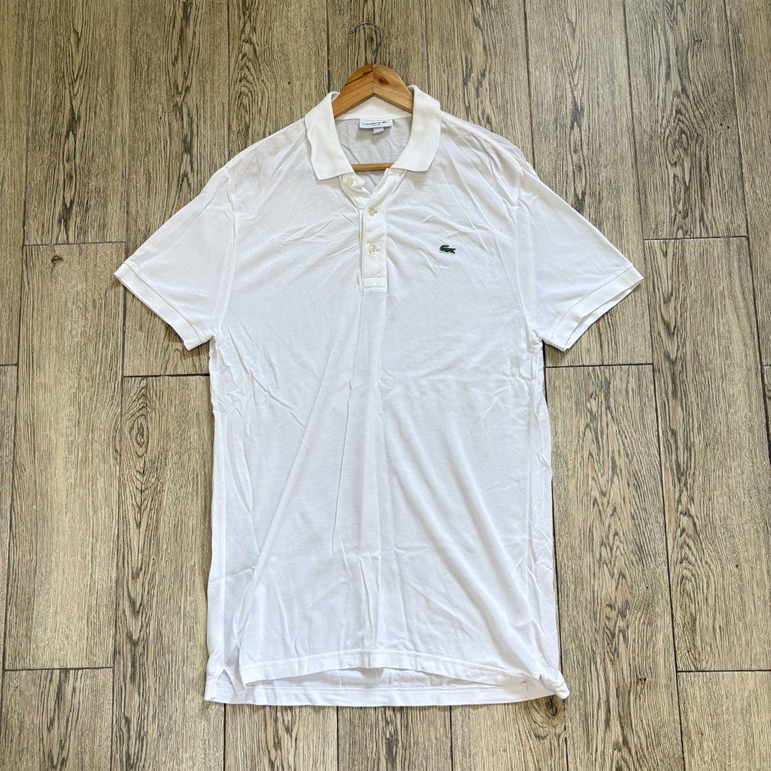 Lacoste White Polo Shirt (Category: Tshirts & Polo Shirts ) located in Imus. Submitted by reloved.nd (Listing ID 1464074342, Image 1). Description: - Classic white Lacoste polo shirt - Iconic green crocodile logo on chest - Two-button placket collar - Versatile for casual or smart-casual outfits - Easy to pair with jeans or shorts.
