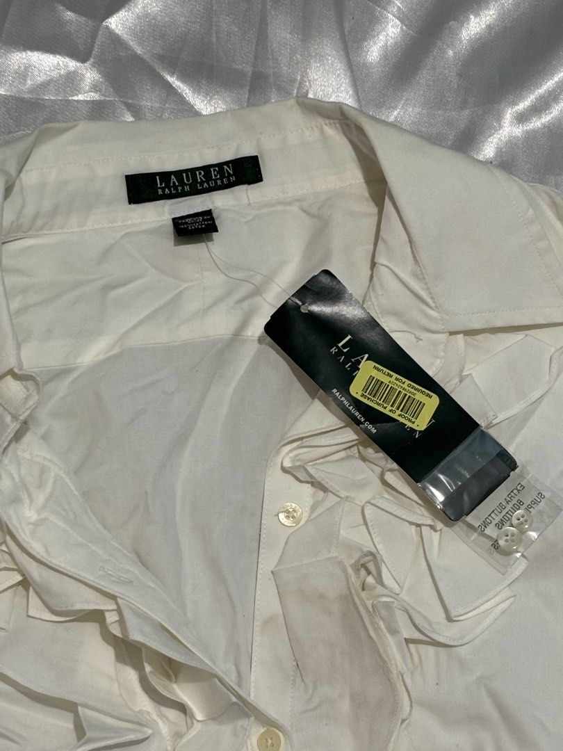 Lauren Ralph Lauren White Ruffle Button-Up Blouse (Category: Blouses) located in Manila. Submitted by k1win4wi (Listing ID 1464069306, Image 3). Description: - Brand: Lauren Ralph Lauren - Color: White - Style: Button-up blouse - Features: Ruffled front detail, long sleeves with button cuffs - Condition: New with original tags attached - Occasion: Ideal for work or a smart casual outfit.