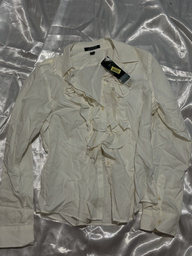 Lauren Ralph Lauren White Ruffle Button-Up Blouse (Category: Blouses) located in Manila. Submitted by k1win4wi (Listing ID 1464069306, Image 1). Description: - Brand: Lauren Ralph Lauren - Color: White - Style: Button-up blouse - Features: Ruffled front detail, long sleeves with button cuffs - Condition: New with original tags attached - Occasion: Ideal for work or a smart casual outfit.