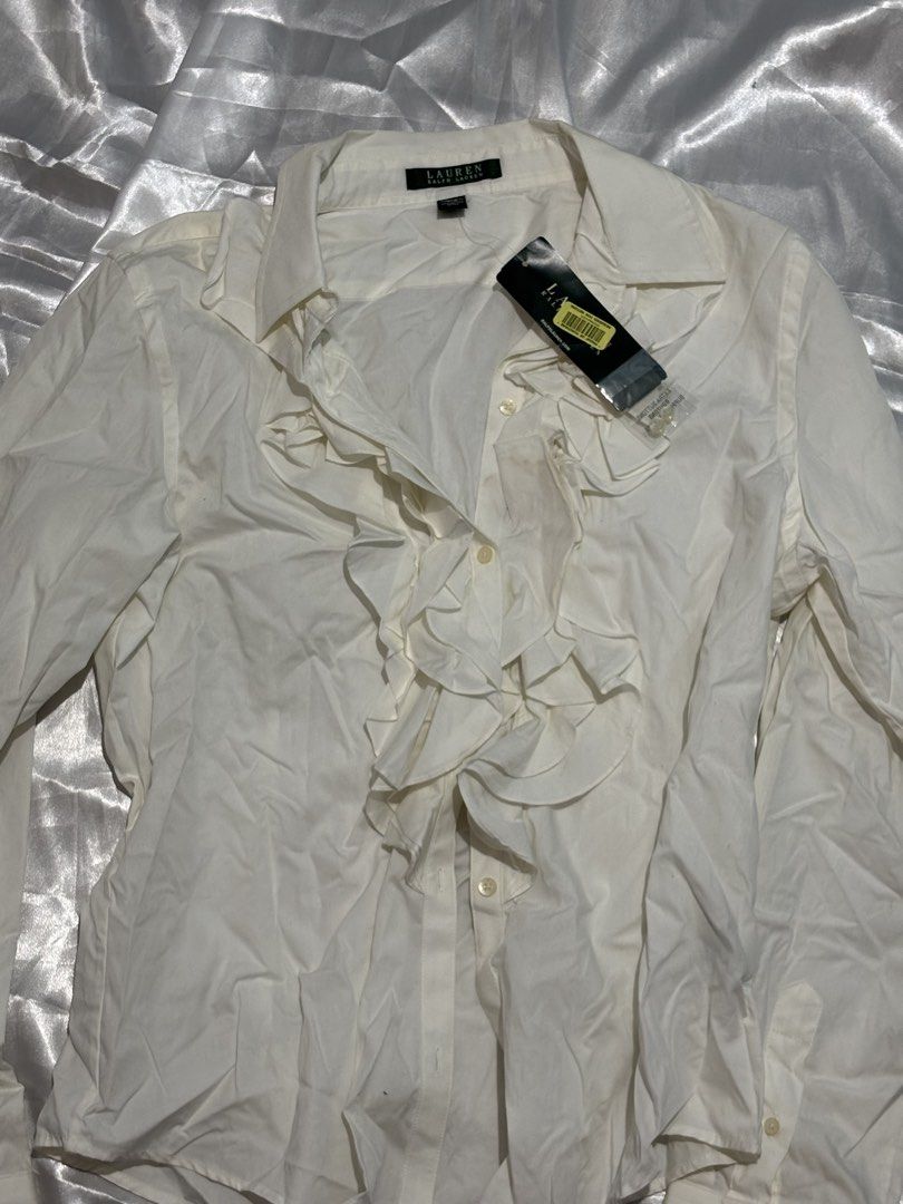 Lauren Ralph Lauren White Ruffle Button-Up Blouse (Category: Blouses) located in Manila. Submitted by k1win4wi (Listing ID 1464069306, Image 2). Description: - Brand: Lauren Ralph Lauren - Color: White - Style: Button-up blouse - Features: Ruffled front detail, long sleeves with button cuffs - Condition: New with original tags attached - Occasion: Ideal for work or a smart casual outfit.