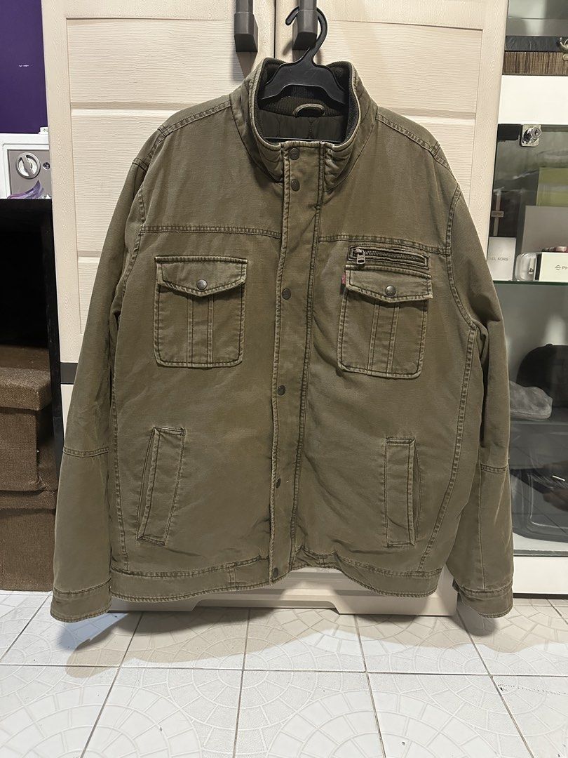 Levi's Olive Green Utility Jacket XXL (Category: Coats, Jackets and Outerwear) located in Valenzuela. Submitted by mmmm14th (Listing ID 1463975319, Image 1). Description: - Olive green Levi's utility jacket - Size XXL - Zip and button-up front closure - Two chest pockets with button closure - Two side pockets - Zippered pocket on left chest - Quilted lining for warmth Chest (Pit to Pit): 24 inches Length: 30 inches Shoulder: ~20–21 inches Good co
