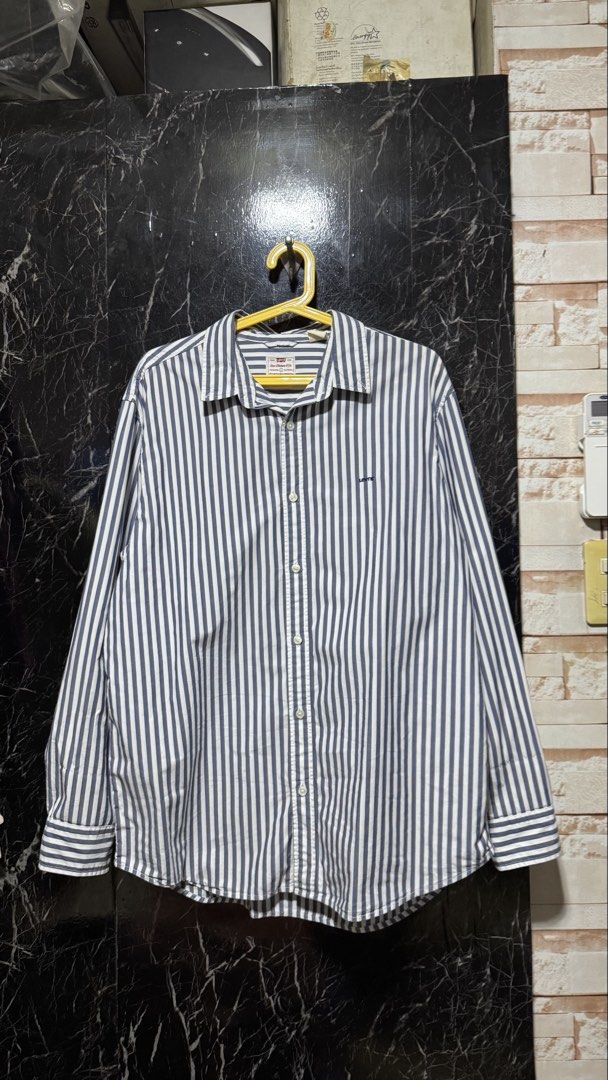 Levi's Striped Button-Down Shirt Relaxed Fit (Category: Shirts) located in Bacoor. Submitted by jiricu1 (Listing ID 1464079577, Image 1). Description: - Classic Levi's button-down shirt - Navy and white vertical stripes - Relaxed fit, Size L - 100% Cotton - Button closure at front and cuffs - Ideal for casual wear.