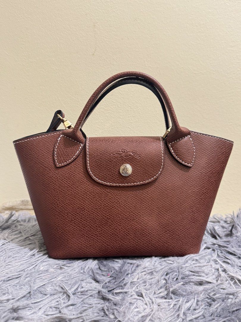 Longchamp epure (Category: Luxury Bags & Wallets) located in Batangas. Submitted by bagsbyann (Listing ID 1463944392, Image 1). Description: - Genuine brown leather handbag - Versatile: Top handles and detachable shoulder strap - Organized interior: Main compartment and a small pocket - Secure closure: Snap button on the flap - Bonus: Comes with a matching leather luggage tag - Ideal for daily use.
