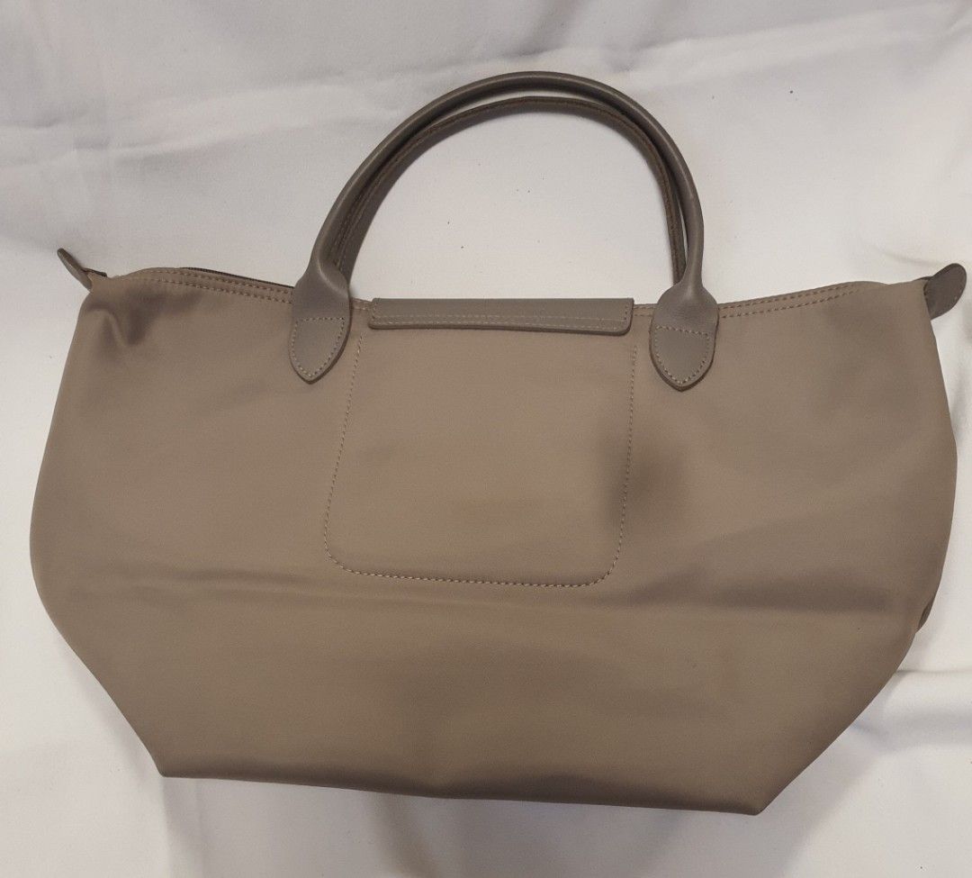 Longchamp Le Pliage Tote Bag (Category: Luxury Bags & Wallets) located in Pasig City. Submitted by angel025 (Listing ID 1464125961, Image 2). Description: - Lightweight and durable nylon material - Genuine leather handles and trim - Secure zipper closure - Convenient interior pocket - Some marks/stains on the base from normal use - Interior is clean and well-maintained - Ideal everyday bag - disregard stain on the bag its just camera dirt.