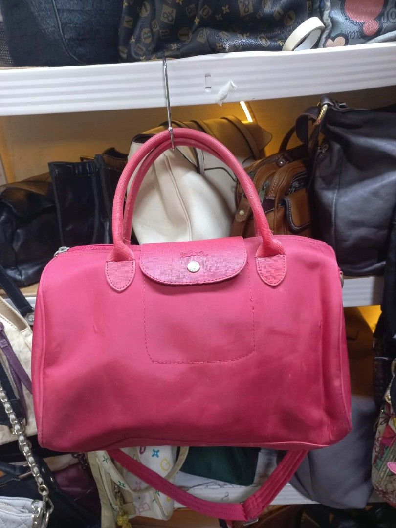Longchamp Pink Nylon Travel Bag (Category: Luxury Bags & Wallets) located in Manila. Submitted by del_thrifts03 (Listing ID 1463945504, Image 1). Description: - Pink nylon duffel bag with elegant leather trim. - Versatile carrying options: comfortable top handles and an adjustable shoulder strap. - Secure main compartment with a zip closure. - Convenient front flap pocket secured with a snap button. - Ideal for weekend trips, gym, or as a travel 
