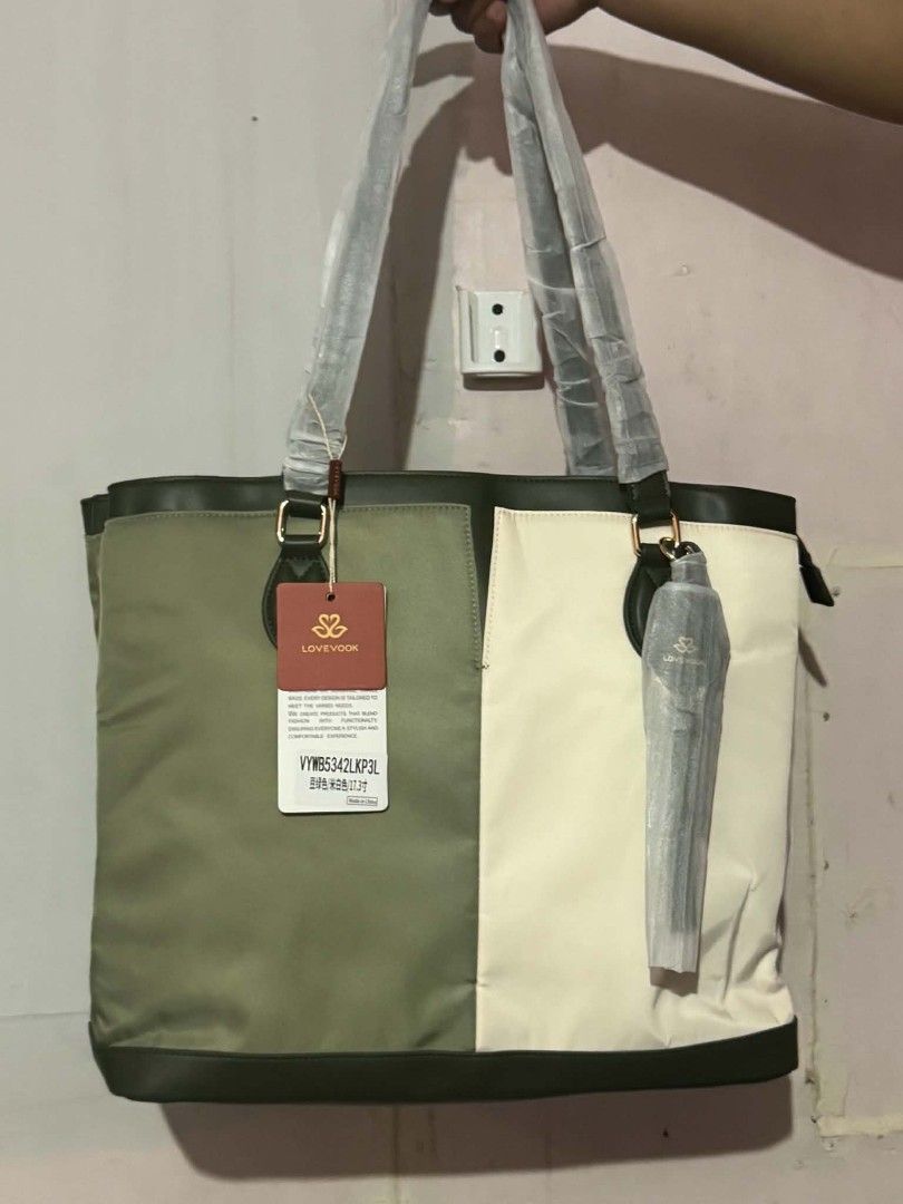 LOVEVOOK Tote Bag (Category: Tote Bags) located in Manila. Submitted by vsballeras1984 (Listing ID 1464066965, Image 1). Description: - LOVEVOOK colorblock tote bag - Stylish olive green and cream panels - Convenient zippered back pocket - Includes a matching pouch - Handles still wrapped in original plastic - Ideal for everyday use.