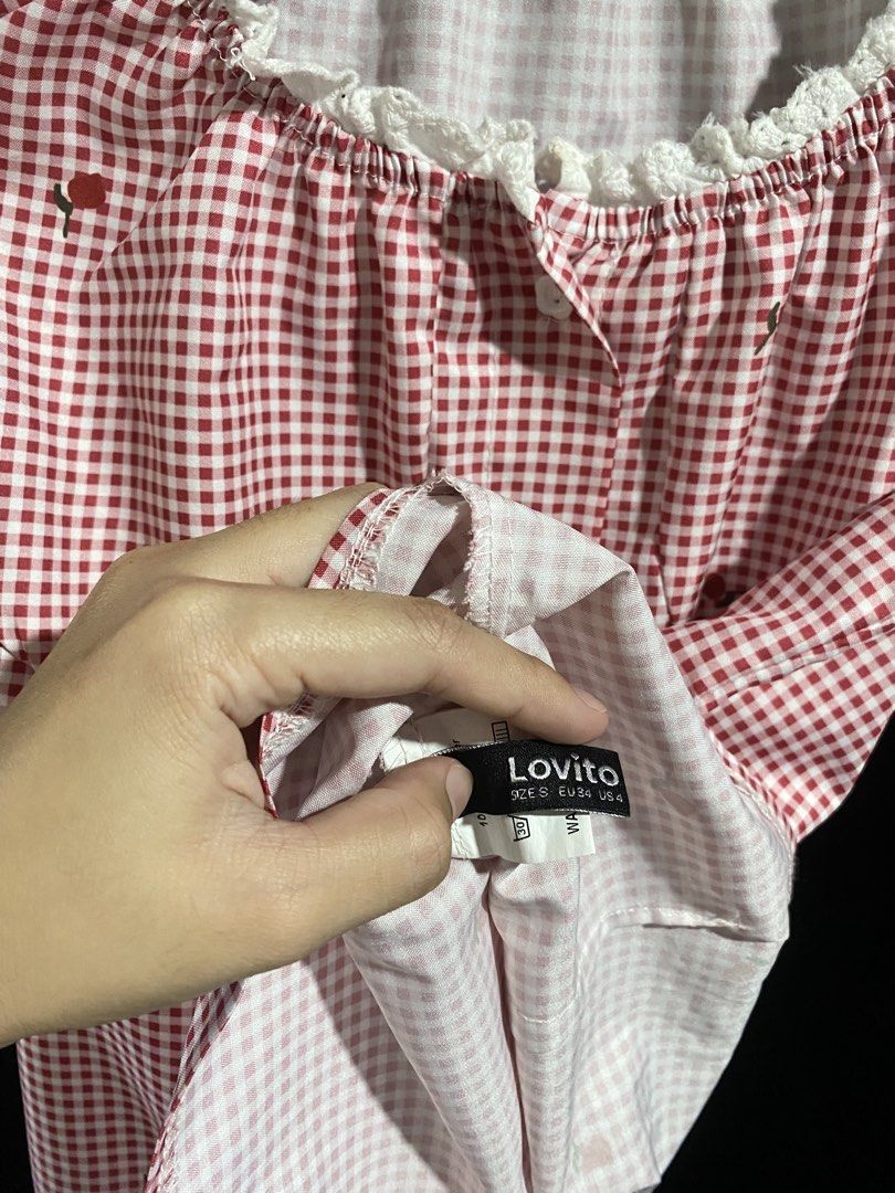 Lovito Red Gingham Strawberry Button Up Top (Category: Blouses) located in Amadeo. Submitted by selectsbysam (Listing ID 1463966784, Image 3). Description: - Adorable red gingham top with a sweet strawberry print. - Features a charming square neckline with delicate lace trim. - Adjustable ties at the shoulders for a perfect fit. - Convenient button-up front closure. - Short sleeves also adorned with lace trim. - Estimated size: Medium (M). - Idea