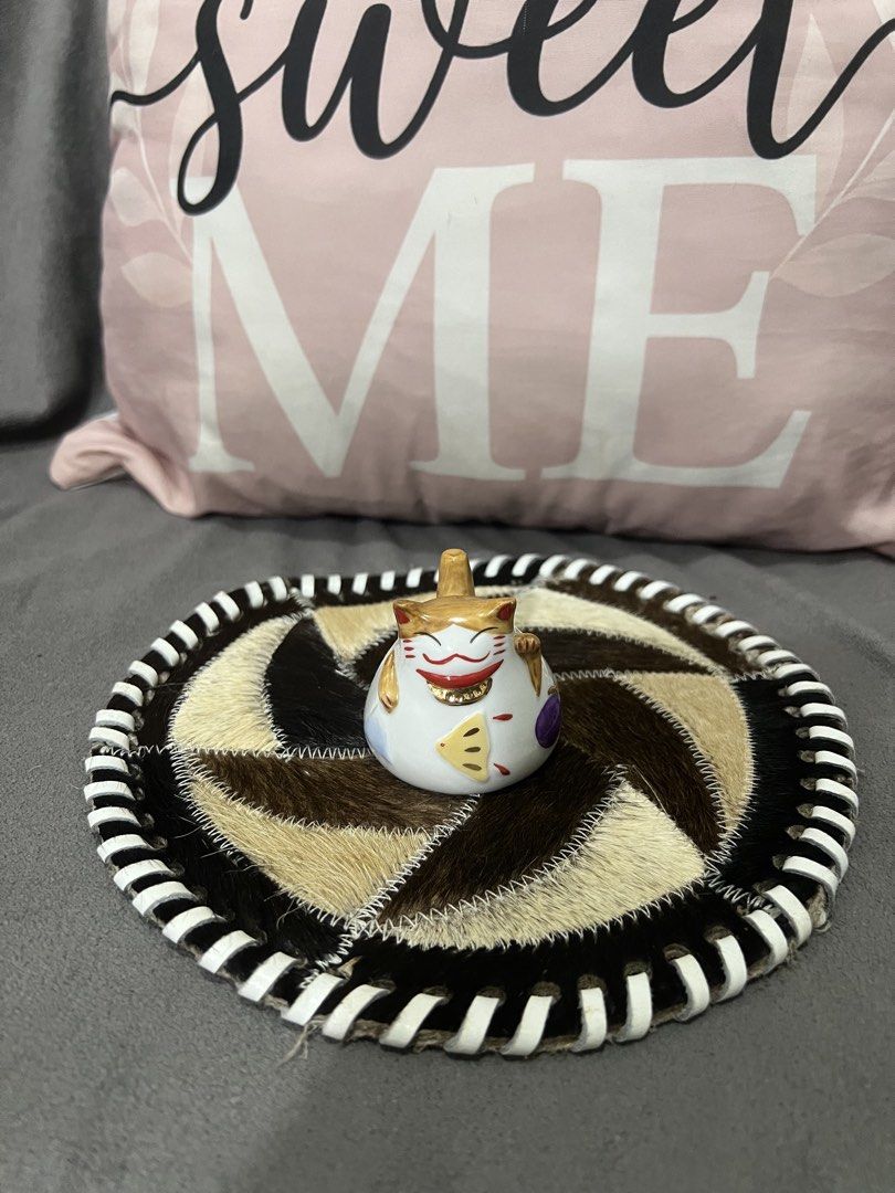 Lucky Cat Maneki Neko Figurine with Unique Coaster (Category: Vintage Collectibles) located in Las Pinas. Submitted by maple0305 (Listing ID 1464047676, Image 1). Description: - Adorable white Maneki Neko cat figurine - Waving paw to bring good luck - Features a charming gold hat and fish detail - Sits on a unique round coaster made of stitched animal fur patches - Coaster has a stylish black and white striped edge - Ideal for home decoration or 