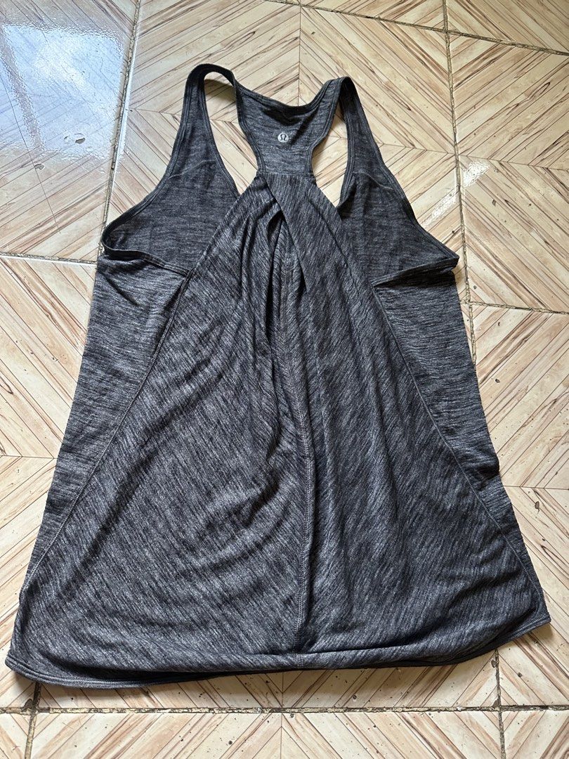 Lululemon Grey Heathered Racerback Tank Top (Category: Sleeveless) located in Angeles City. Submitted by alejeong27 (Listing ID 1463968698, Image 2). Description: - Grey heathered Lululemon tank top - Racerback style - Lightweight and breathable fabric - Unique twisted detail on the back - Lululemon logo on the front - Ideal for workouts or casual wear.