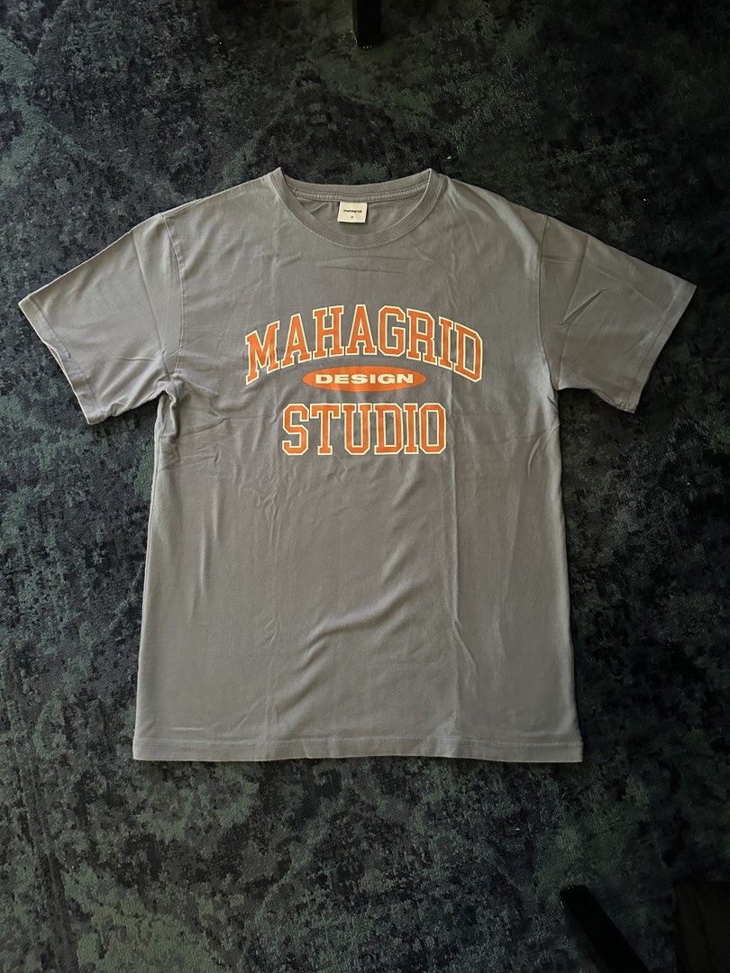 MAHAGRID STUDIO Shirt (Category: Tshirts & Polo Shirts ) located in Makati City. Submitted by smolpapi (Listing ID 1464135464, Image 1). Description: - MAHAGRID DESIGN STUDIO grey t-shirt - Features orange brand lettering across the chest - Korean Brand - Perfect for everyday wear - Please check photos for condition details.