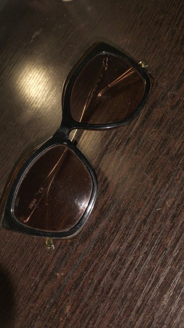 MCM Sunglasses (Category: Sunglasses & Eyewear) located in Las Pinas. Submitted by _dyien (Listing ID 1464053225, Image 2). Description: - MCM Sunglasses - Color: Black frames with brown lenses - Condition: Scratches on lenses (please check photos) - Sold as is.