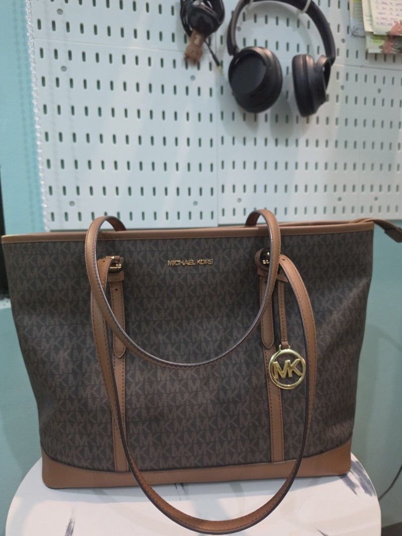 Michael Kors Monogram Tote Bag (Category: Luxury Bags & Wallets) located in Quezon City. Submitted by closetbysamita (Listing ID 1458357757, Image 1). Description: Michael Kors Voyager / Jet Set Large Signature Logo Tote Bag in classic brown coated canvas with acorn brown leather trim and gold-tone hardware. ​Material: MK Signature Monogram Coated Canvas with Genuine Leather handles and bottom trim ​Color: Brown / Acorn (Tan) ​Details: Dual adjus