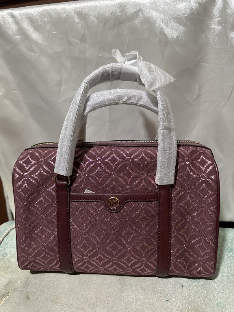 Michael Kors Signature Pattern Satchel Bag (Category: Shoulder Bags) located in Balanga. Submitted by jk2025. (Listing ID 1463952979, Image 1). Description: - Michael Kors satchel bag - Beautiful plum color - All-over signature MK geometric pattern - Front pocket with MK logo hardware - Top zip closure - Handles still have protective plastic wrap - Versatile for everyday use or evening outings.