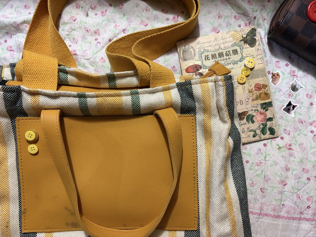 Mustard Striped Canvas Tote/Shoulder Bag (Category: Luxury Bags & Wallets) located in Muntinlupa City. Submitted by herellas0504 (Listing ID 1464083179, Image 2). Description: Mustard Striped Canvas Tote/Shoulder Bag Mine: 100 | Lock: 170 ———————————— perfect for school & casual outings spacious, can put notebooks, iPad, phone, aniks, etc issue: see slides (w/small stain front outside & need see inside pocket, broken zipper but still working just