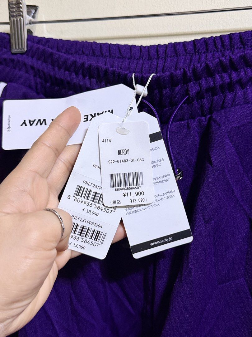 Nerdy Purple Cargo Track Pants (Category: Joggers) located in Paete. Submitted by skydruemadison (Listing ID 1464044192, Image 3). Description: - Brand: Nerdy - Color: Purple - Style: Cargo track pants - Features: Classic three stripes down the side, Nerdy logo on pocket - Waistband: Elastic with drawstring - Pockets: Front, back, and two cargo pockets on legs - Ideal for: Casual wear, lounging.