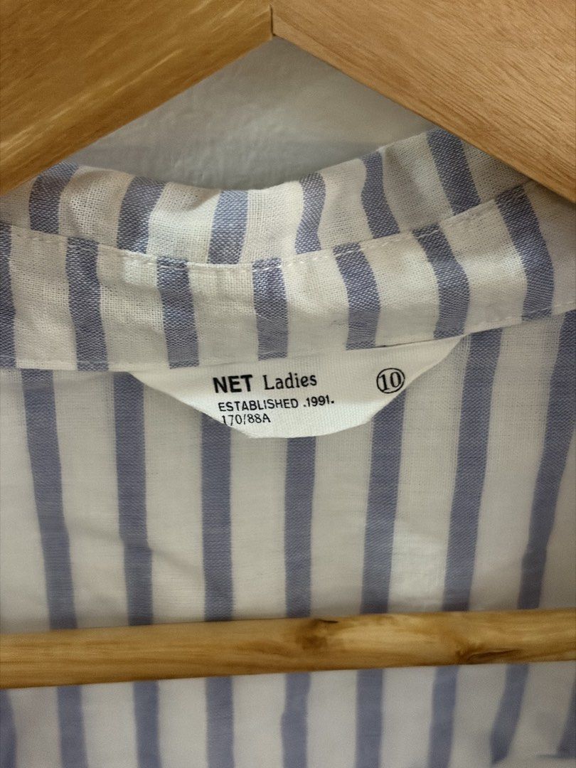 NET Light Blue and White Striped Button-Up Shirt (Category: Blouses) located in San Juan City. Submitted by sel.ler (Listing ID 1463987257, Image 2). Description: - Classic blue and white striped design - Brand: NET Ladies - Short sleeves with button tabs for roll-up option - Two chest pockets with button closures - Lightweight fabric, ideal for warm weather - Easy to style for casual or smart-casual outfits.