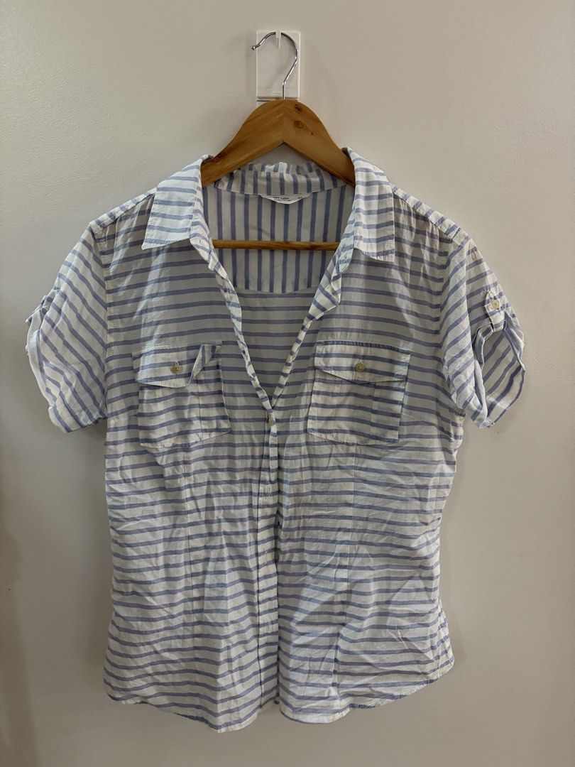 NET Light Blue and White Striped Button-Up Shirt (Category: Blouses) located in San Juan City. Submitted by sel.ler (Listing ID 1463987257, Image 1). Description: - Classic blue and white striped design - Brand: NET Ladies - Short sleeves with button tabs for roll-up option - Two chest pockets with button closures - Lightweight fabric, ideal for warm weather - Easy to style for casual or smart-casual outfits.