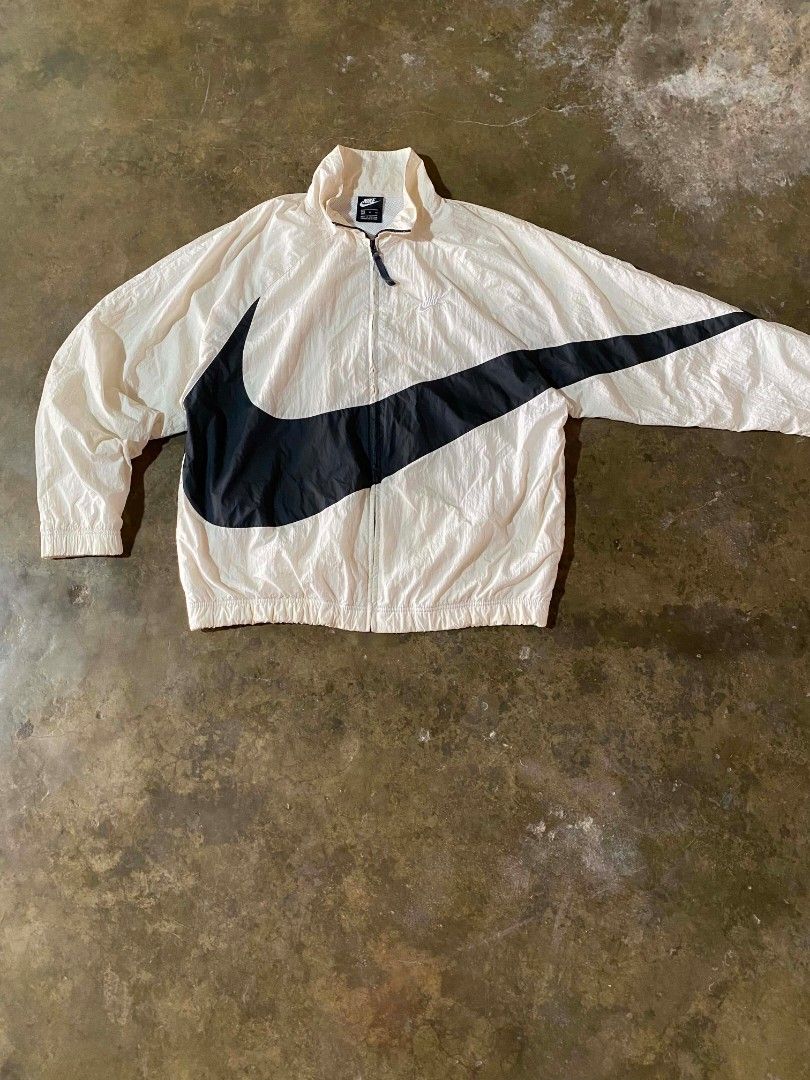 Nike Big Swoosh Windbreaker Jacket (Category: Coats, Jackets and Outerwear) located in Polomolok. Submitted by aldrex_18 (Listing ID 1463979015, Image 1). Description: - Nike windbreaker - Features a large black swoosh graphic on the front - Lightweight material, ideal for layering - Full zip closure - Drawstring hood - Small embroidered Nike logo on the chest - Made in Vietnam.