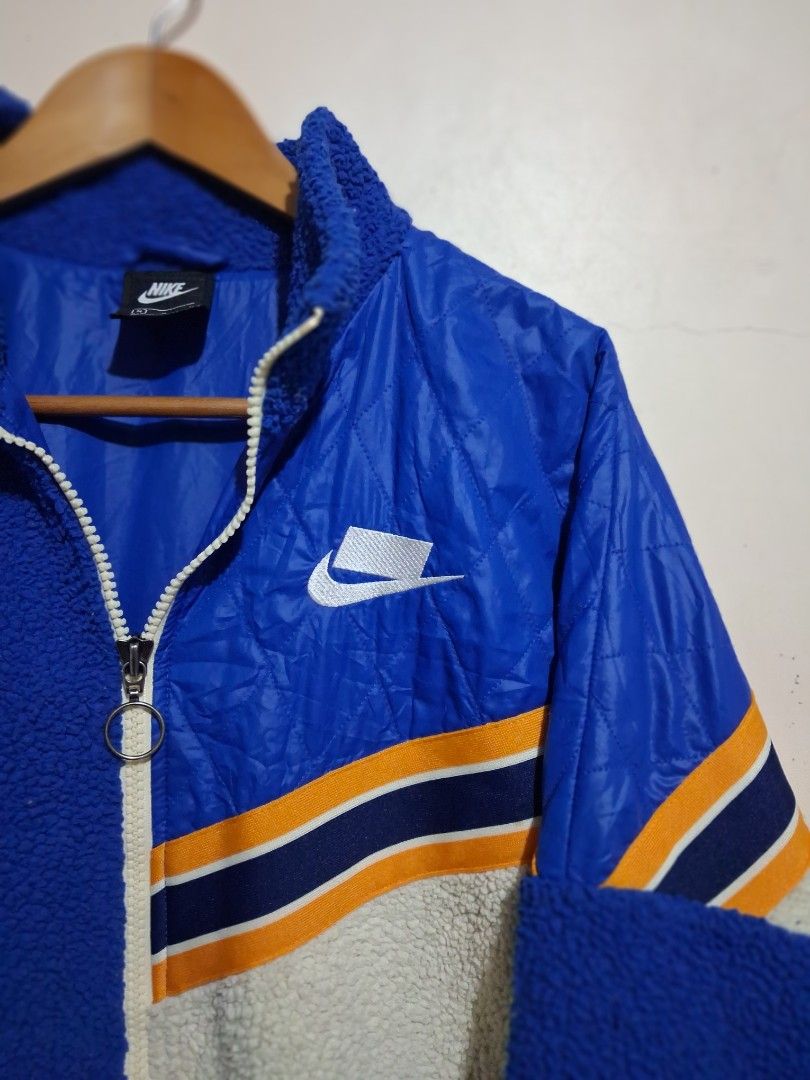 Nike Colorblock Fleece and Nylon Jacket (Category: Coats, Jackets and Outerwear) located in Manila. Submitted by randf_selections (Listing ID 1464124264, Image 3). Description: Cool Nike jacket with a mix of blue fleece and blue quilted nylon. Features orange and white stripe details on the sleeves. Zipper closure. Great for staying warm and stylish. Perfect for casual wear..
