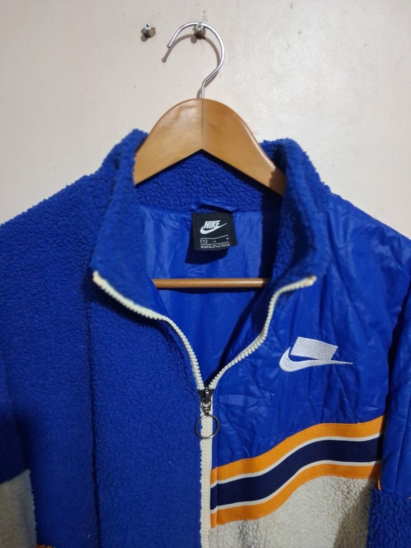 Nike Colorblock Fleece and Nylon Jacket (Category: Coats, Jackets and Outerwear) located in Manila. Submitted by randf_selections (Listing ID 1464124264, Image 2). Description: Cool Nike jacket with a mix of blue fleece and blue quilted nylon. Features orange and white stripe details on the sleeves. Zipper closure. Great for staying warm and stylish. Perfect for casual wear..