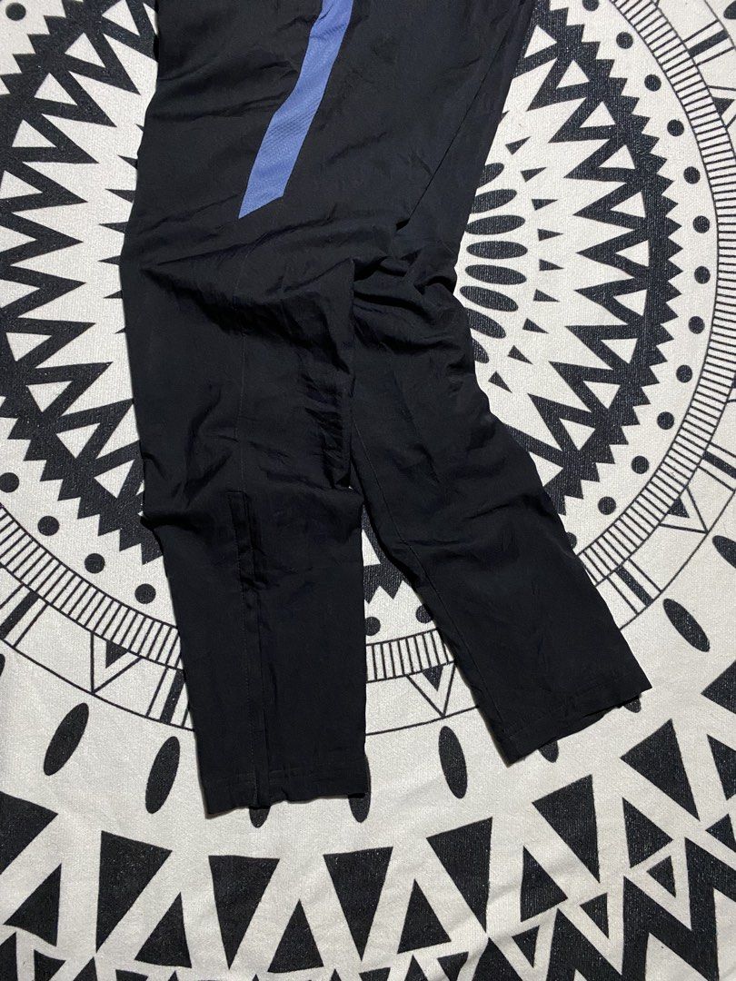 Nike Dri-FIT Black Track Pants (Category: Joggers) located in Badiangan. Submitted by iralorana.thrift (Listing ID 1463960273, Image 3). Description: - Black Nike track pants - Blue accent details - Iconic Nike Swoosh logo - Dri-FIT technology for moisture-wicking - Comfortable elastic waistband with drawstring - Zippers at the ankle for adjustable fit - Ideal for athletic activities or everyday casual wear.