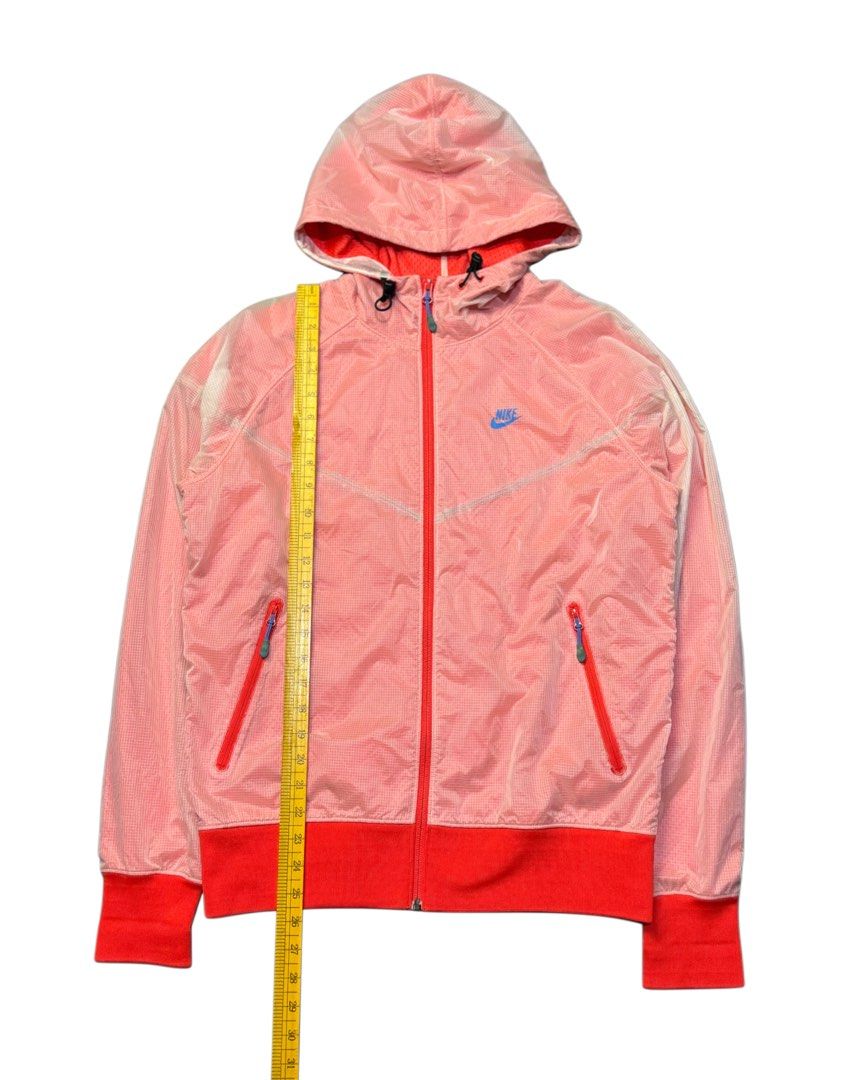 Nike RED Hooded Windbreaker Jacket (Category: Coats, Jackets and Outerwear) located in Caloocan City. Submitted by mzcollection_349 (Listing ID 1464015568, Image 3). Description: - Pink Nike windbreaker jacket - Features a hood - Red trim on cuffs and hem - Zip-up front closure - Two zip pockets for secure storage - Lightweight material, ideal for layering - Versatile for casual wear or light workouts.