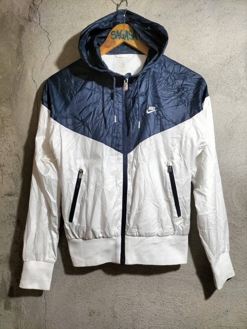 Nike Windrunner Hooded Jacket (Category: Coats, Jackets and Outerwear) located in Valencia. Submitted by cabisaythriftshop (Listing ID 1463986457, Image 1). Description: - Classic Nike Windrunner jacket - Blue and white color block design - Lightweight and hooded - Full zip front with zippered pockets - Ideal for layering or light weather protection - Easy to pack and wear.