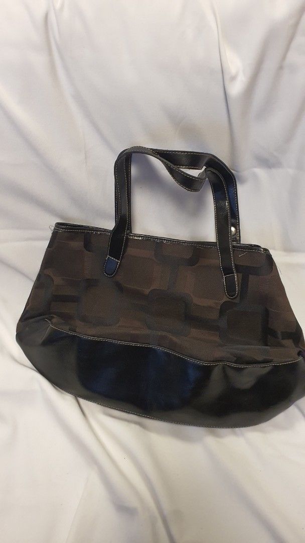 Nine West Brown Monogram Shoulder Bag (Category: Shoulder Bags) located in Pasig City. Submitted by angel025 (Listing ID 1464125974, Image 2). Description: - Classic Nine West shoulder bag - Brown monogram pattern with black faux leather trim - Clean interior with one zippered pocket - Spacious and ideal for everyday essentials.