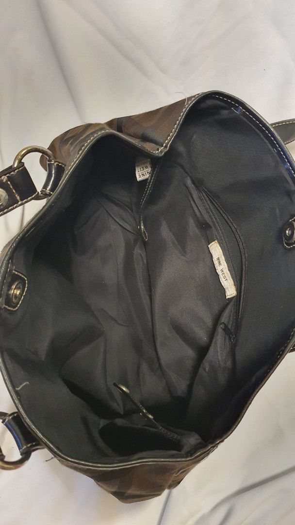 Nine West Brown Monogram Shoulder Bag (Category: Shoulder Bags) located in Pasig City. Submitted by angel025 (Listing ID 1464125974, Image 3). Description: - Classic Nine West shoulder bag - Brown monogram pattern with black faux leather trim - Clean interior with one zippered pocket - Spacious and ideal for everyday essentials.