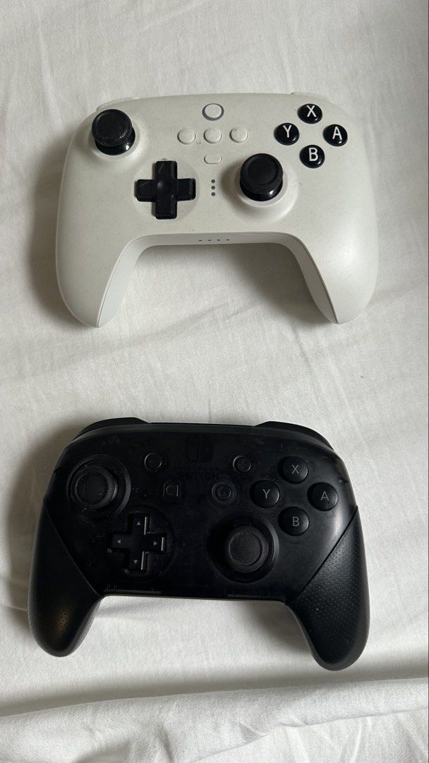Nintendo Switch Pro Controller & 8BitDo Controller (Category: Controllers) located in Singapore. Submitted by azeighn (Listing ID 1463965676, Image 1). Description: - Black Nintendo Switch Pro Controller - White 8BitDo Controller - Both in good working condition - Ideal for multiplayer gaming - Perfect as replacement controllers - Bundle deal available - Don't miss out!.