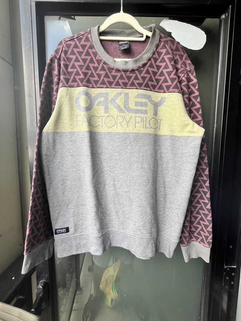 Oakley Factory Pilot Crewneck Sweatshirt (Category: Coats, Jackets and Outerwear) located in Manila. Submitted by kingjamessthriftt (Listing ID 1464005363, Image 1). Description: - Oakley Factory Pilot Sweatshirt - Crewneck, long sleeves - Grey main body with yellow chest stripe - Geometric pattern on upper part and sleeves - Size: Medium (M) - Made in China.