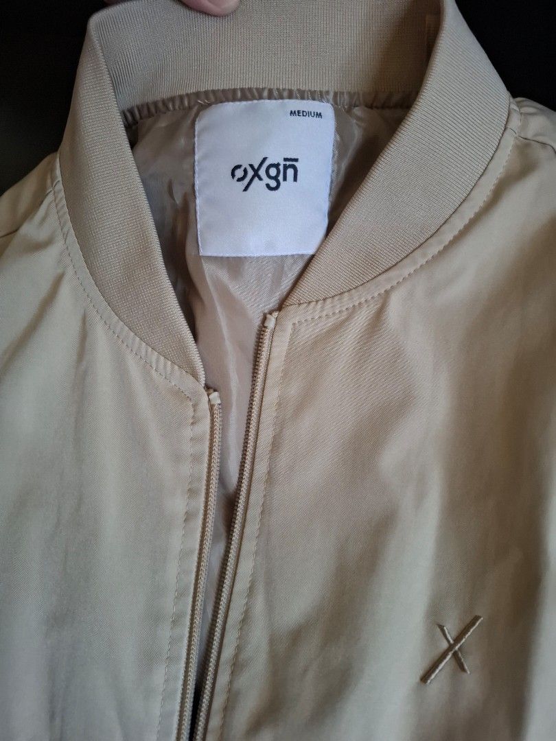 Oxgn Bomber Jacket Medium (Category: Coats, Jackets and Outerwear) located in Muntinlupa City. Submitted by googoosh_collection (Listing ID 1463998942, Image 1). Description: - Brand: Oxgn - Color: Khaki - Style: Bomber Jacket - Size: Medium - Features: Zip-up front, pockets - Detail: Small embroidered logo on chest - Occasion: Casual wear *RFS: Maliit sa akin di nagamit bagong bago pa) MOD: Lalamove/ Gogo express (Shipping fee shouldered by the 