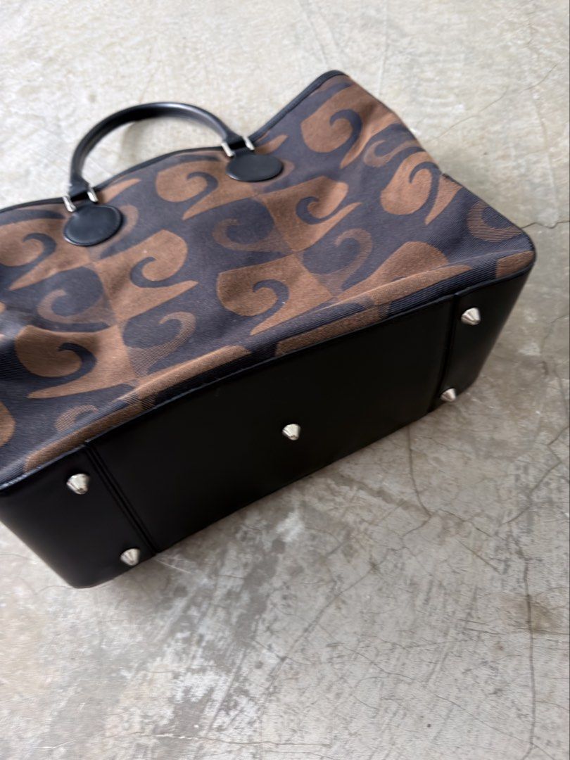 Pierre Cardin Canvas Tote Bag (Category: Tote Bags) located in Alfonso. Submitted by jbcamet (Listing ID 1464023352, Image 2). Description: - Authentic Pierre Cardin tote bag - Unique brown and black patterned exterior - Genuine leather trim and handles - Protective metal studs on the bottom - Secure snap closure - Spacious main compartment - Interior zippered pockets for organization - Ideal for everyday use.