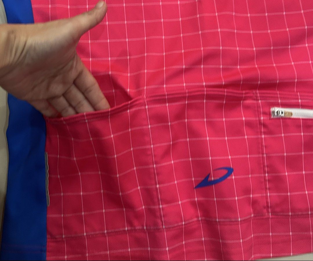 Pink Grid Cycling running pickleball Jersey (Category: Activewear) located in Plaridel. Submitted by ilovebubu28 (Listing ID 1464020918, Image 3). Description: - Pink grid cycling jersey with blue side panels - Features 'DESPERADO' logo on front and back - Full zip closure for easy ventilation - Three back pockets for storage, one with a zipper - Made in Japan for quality craftsmanship - Ideal for your next cycling , running adventure.