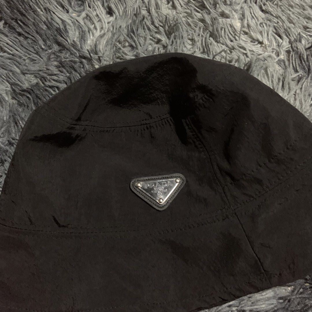 Prada Black Nylon Bucket Hat (Category: Caps & Hats) located in Compostela. Submitted by anyastark (Listing ID 1464126183, Image 2). Description: - Prada bucket hat - Black nylon material - Iconic Prada triangle logo on the front - Perfect for sunny days or stylish outfits - Simple and classic design.