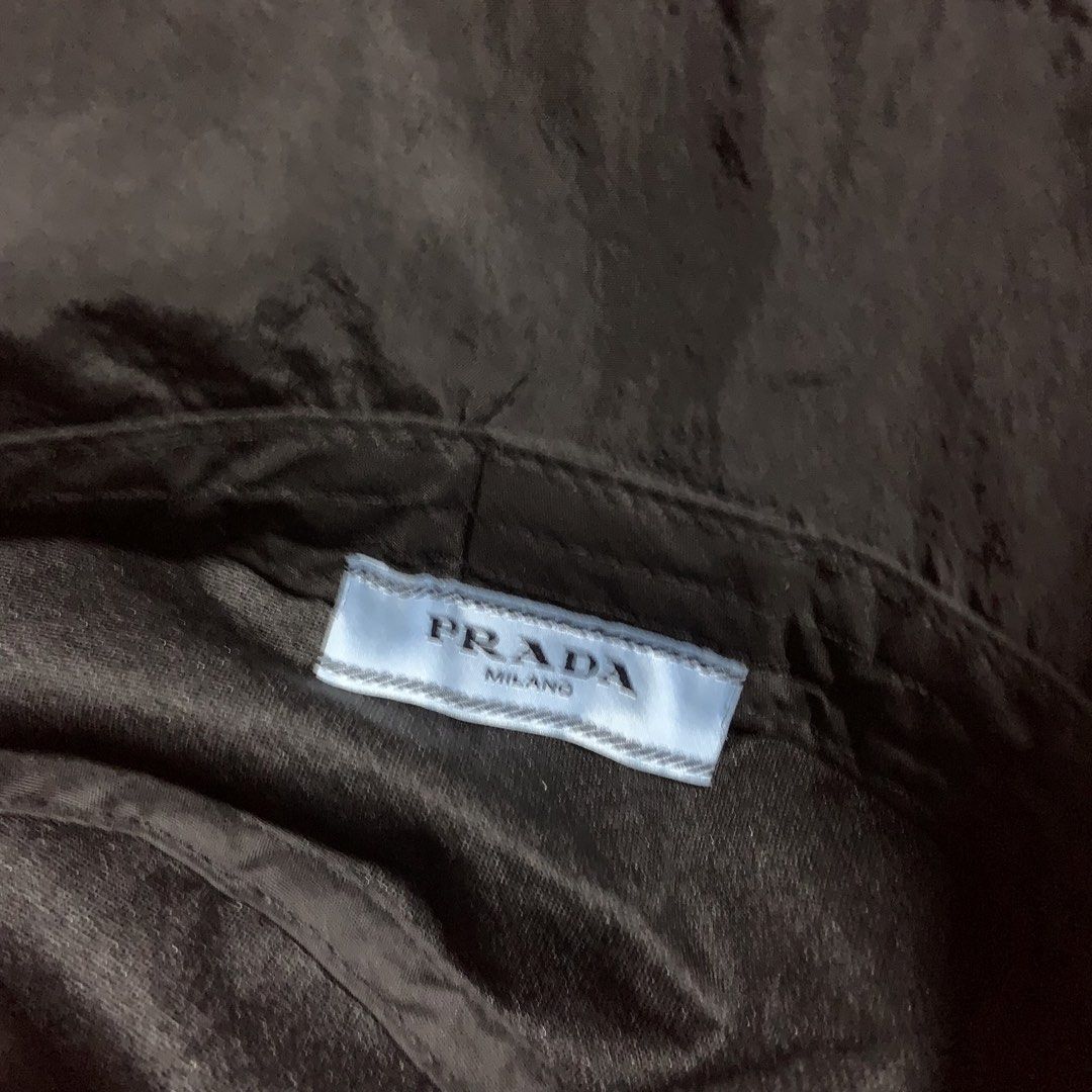Prada Black Nylon Bucket Hat (Category: Caps & Hats) located in Compostela. Submitted by anyastark (Listing ID 1464126183, Image 3). Description: - Prada bucket hat - Black nylon material - Iconic Prada triangle logo on the front - Perfect for sunny days or stylish outfits - Simple and classic design.