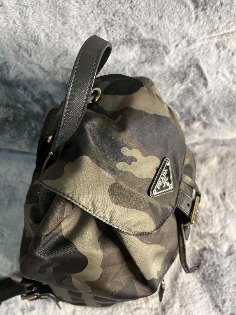 Prada Camouflage Nylon Backpack (Category: Backpacks) located in Legazpi City. Submitted by rhumbalagu04057 (Listing ID 1463961636, Image 2). Description: - Authentic Prada Backpack - Classic Camouflage Print - Durable Nylon Material - Leather Trim and Straps - Drawstring Closure with Buckle Flap - Front Zip Pocket - Adjustable Shoulder Straps - Ideal for Everyday Use or Travel.