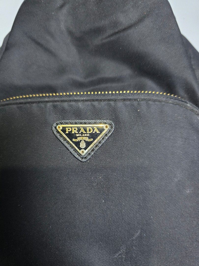 Prada Nylon Backpack Black (Category: Backpacks) located in Labangan. Submitted by felicityamry (Listing ID 1464077636, Image 3). Description: Prada Duet Re-Nylon buck - Authentic Prada backpack - Durable nylon material - Front zip pocket with iconic Prada triangle logo - Secure drawstring closure - Adjustable straps for comfort - Elegant gold-tone hardware - Ideal for everyday wear.