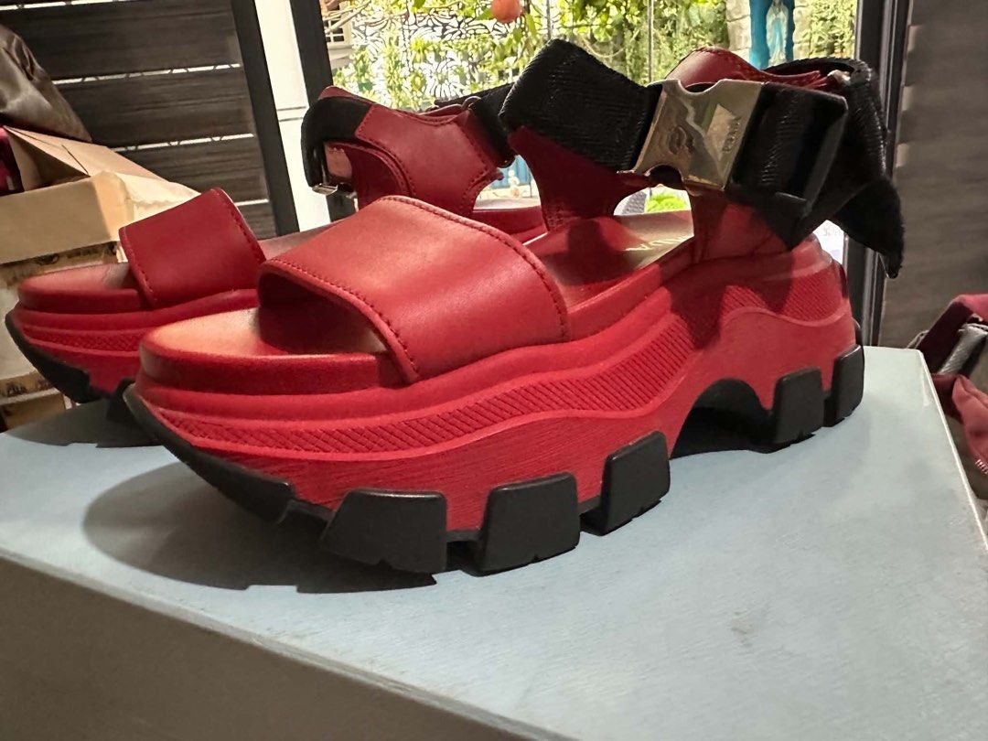 Prada Red Platform Sandals (Category: Flats & Sandals) located in Manila. Submitted by thriftnipapi7 (Listing ID 1464039841, Image 3). Description: - Authentic Red Prada Platform Sandals - Features a chunky sole with black accents - Adjustable straps with secure buckle closure - Exceptionally comfortable and stylish - Versatile for dressing up or down - Original box included.